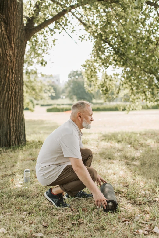 a man kneeling in the grass with a skateboard, unsplash, gray haired, sitting under a tree, looking sad, avatar image