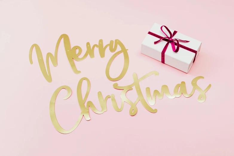 a white gift box sitting on top of a pink surface, by Julia Pishtar, trending on unsplash, flowing lettering, gold decorations, merry england, die - cut sticker