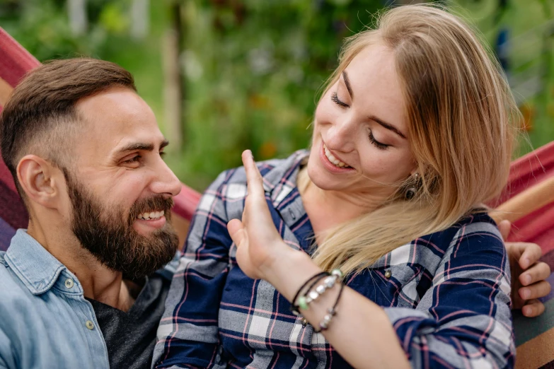 a man and a woman sitting in a hammock, pexels contest winner, happening, hand on his cheek, profile image, earing a shirt laughing, man proposing his girlfriend