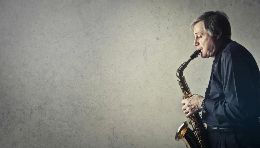 a man playing a saxophone against a wall, an album cover, trending on pixabay, fantastic realism, an oldman, on grey background, gorgeous lady, full width