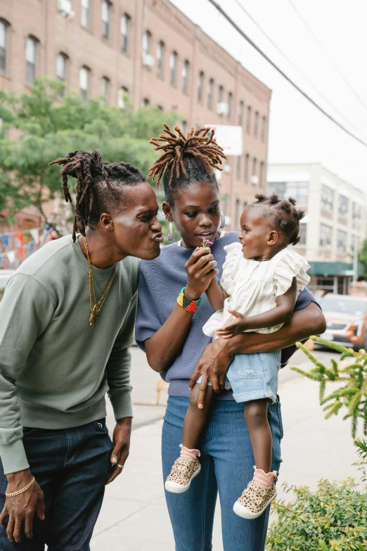 a group of people standing next to each other on a sidewalk, trending on unsplash, black arts movement, portrait of family of three, licking, dreadlock breed hair, brooklyn