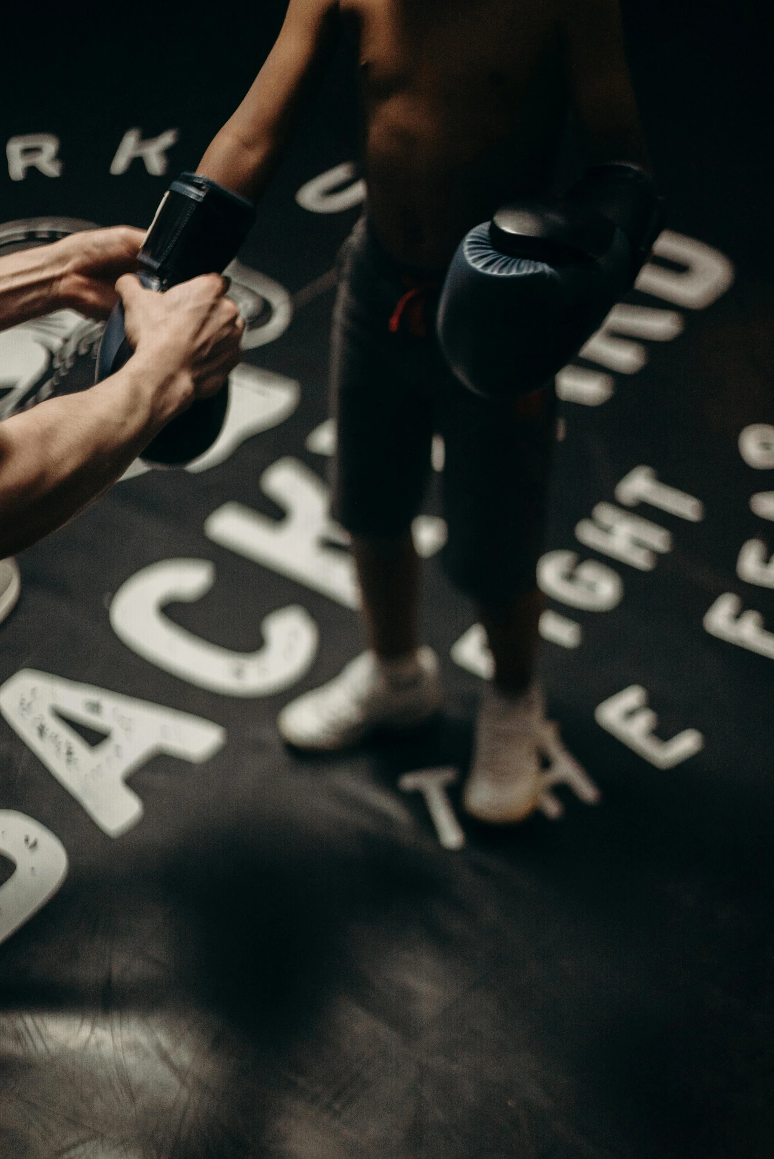 a couple of men standing next to each other on a boxing ring, by Adam Marczyński, pexels contest winner, graffiti, white font on black canvas, camera close to the legs, gif, high angle close up shot