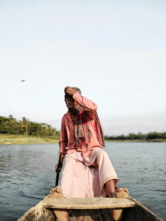 a man sitting on top of a wooden boat, by Sunil Das, trending on unsplash, hurufiyya, an old lady with red skin, joel sternfeld, in louisiana, woman with rose tinted glasses