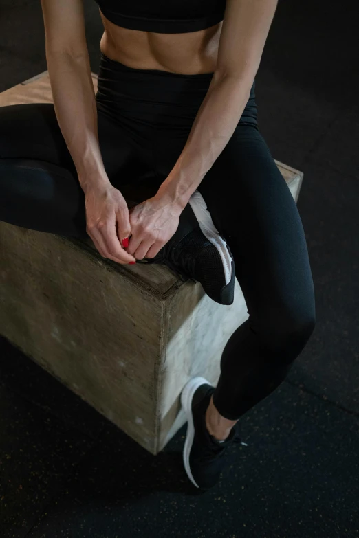 a woman sitting on top of a wooden box, releasing pain, local gym, palladium veins, scabs