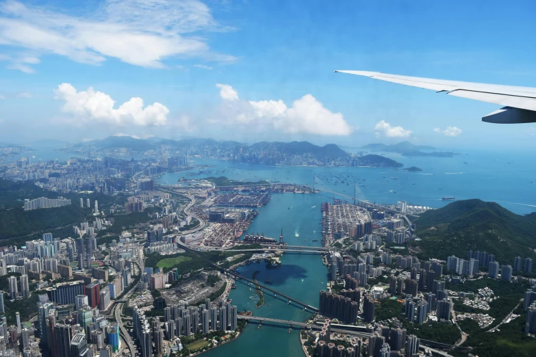 a view of a city from an airplane, pexels contest winner, hurufiyya, a still of kowloon, thumbnail, tropical coastal city, take off