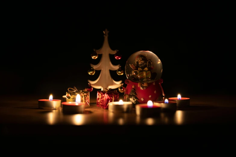 a group of candles sitting on top of a table, a still life, pexels, figuration libre, snowglobe, profile image, dim lit, toy photography