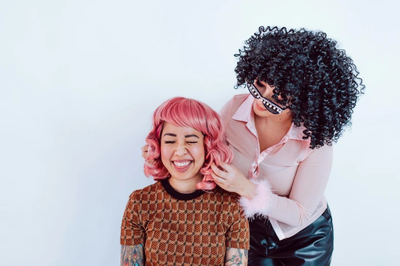 a woman with pink hair cutting another woman's hair, by Julia Pishtar, trending on pexels, kitsch movement, black curly hair, head bent back in laughter, posed, wig
