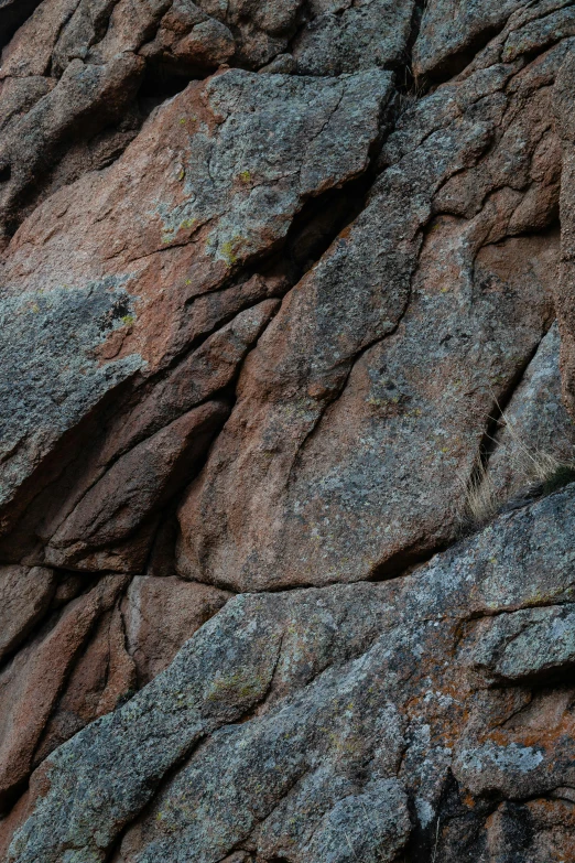 a man on a rock climbing up the side of a mountain, an album cover, by artist, unsplash, australian tonalism, abstract detail, ((rocks)), complex pattern, background image