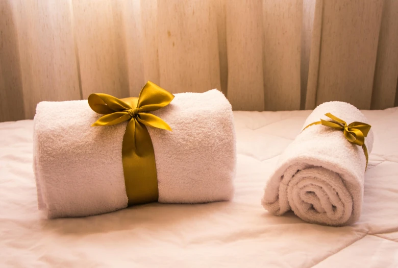 a couple of towels sitting on top of a bed, pexels contest winner, art nouveau, golden ribbon, holiday season, spa, gloating