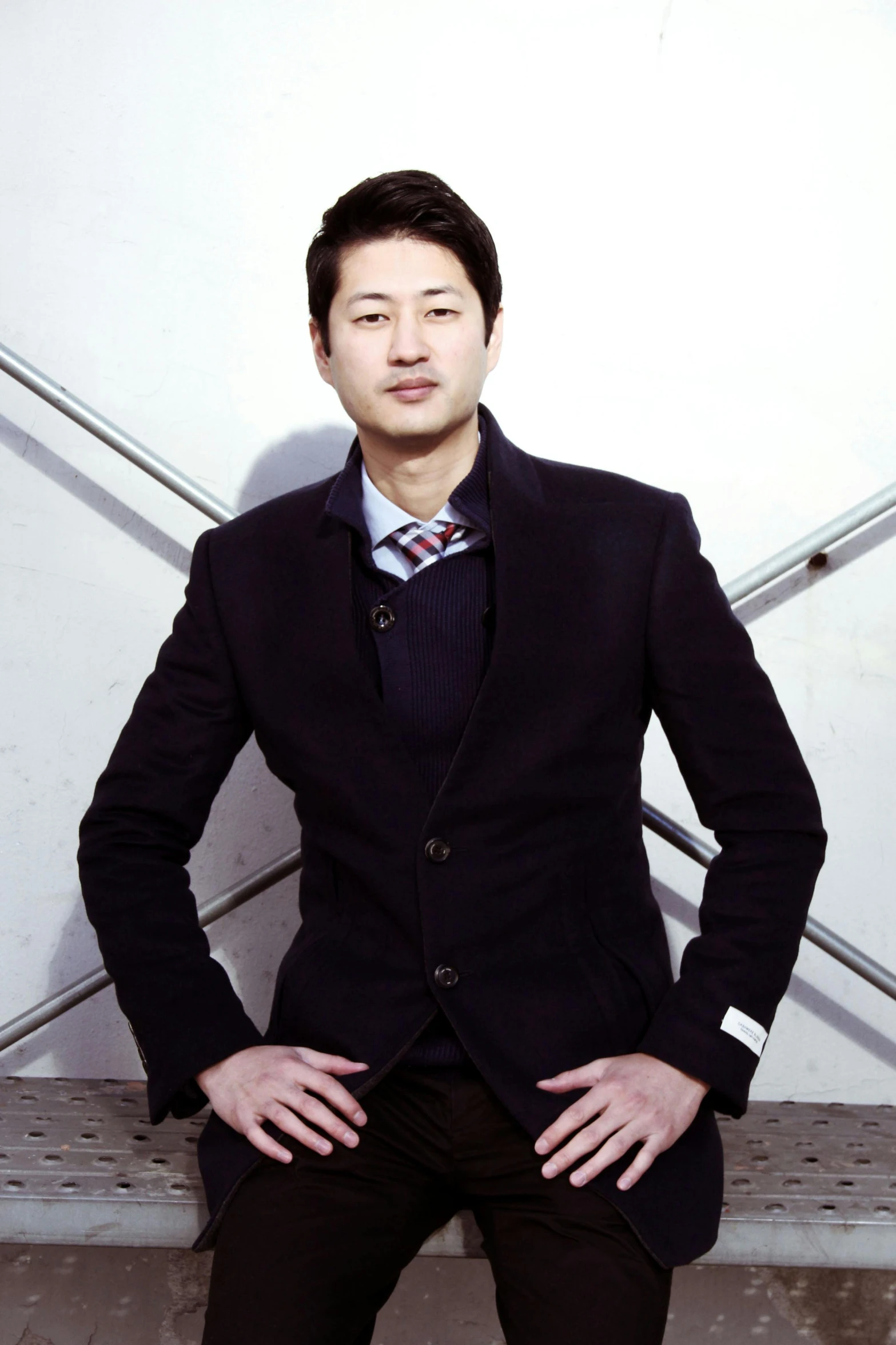 a man in a suit sitting on a bench, shin hanga, passport photo, standing with a black background, wearing business casual dress, sun-hyuk kim