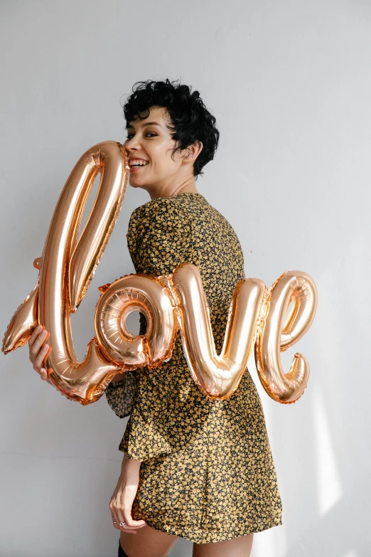 a woman in a leopard print dress holding a love balloon, rose gold, curated collection, lgbtq, bubble letters