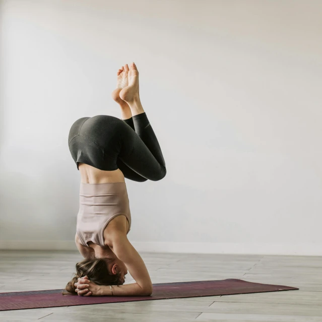 a woman doing a handstand pose on a yoga mat, pexels contest winner, arabesque, focused on neck, full body sarcastic pose, praying posture, indoor picture