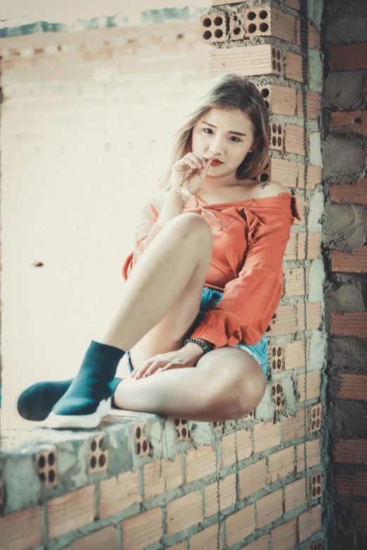 a woman sitting on a window sill talking on a cell phone, pexels contest winner, realism, sexy girl wearing shorts, dang my linh, warm color clothes, 18 years old