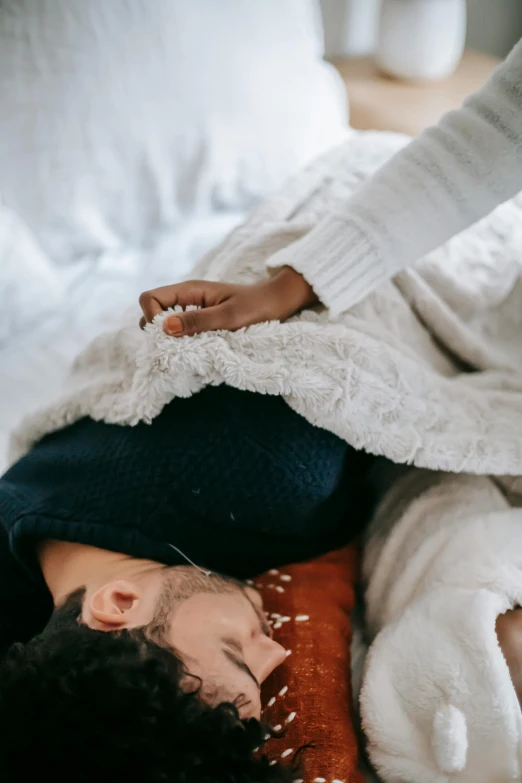 a man and woman laying on a bed under a blanket, by Jessie Algie, trending on pexels, acupuncture treatment, cold texture, gif, winter