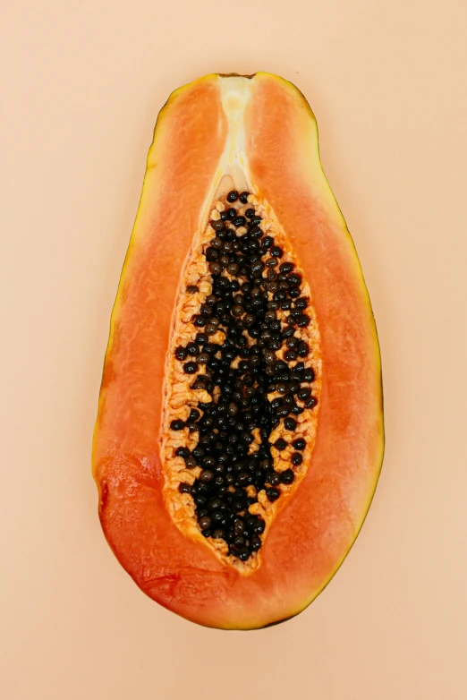 a papana cut in half on a white surface, by Gavin Hamilton, trending on pexels, black and terracotta, abundant fruition seeds, juicy color, 1960s-era