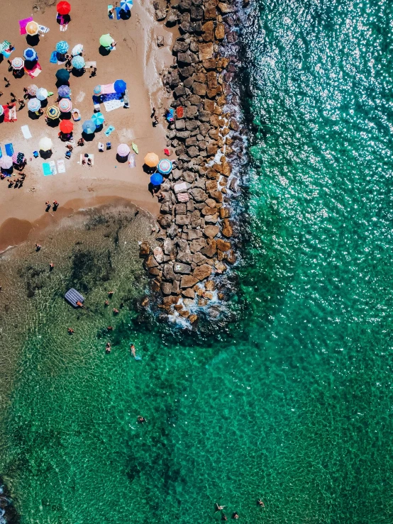 a group of people standing on top of a sandy beach, flatlay, green water, capri coast, colorful”