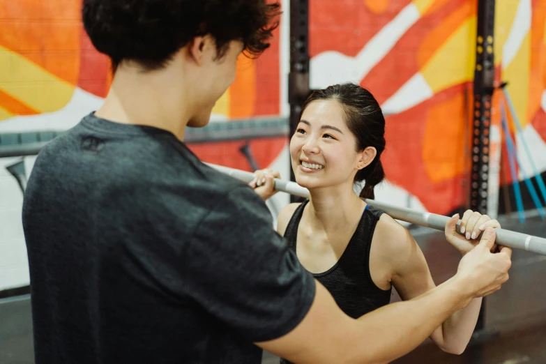 a woman holding a baseball bat next to a man, pexels contest winner, local gym, ukiyo, smiling at each other, jen bartel