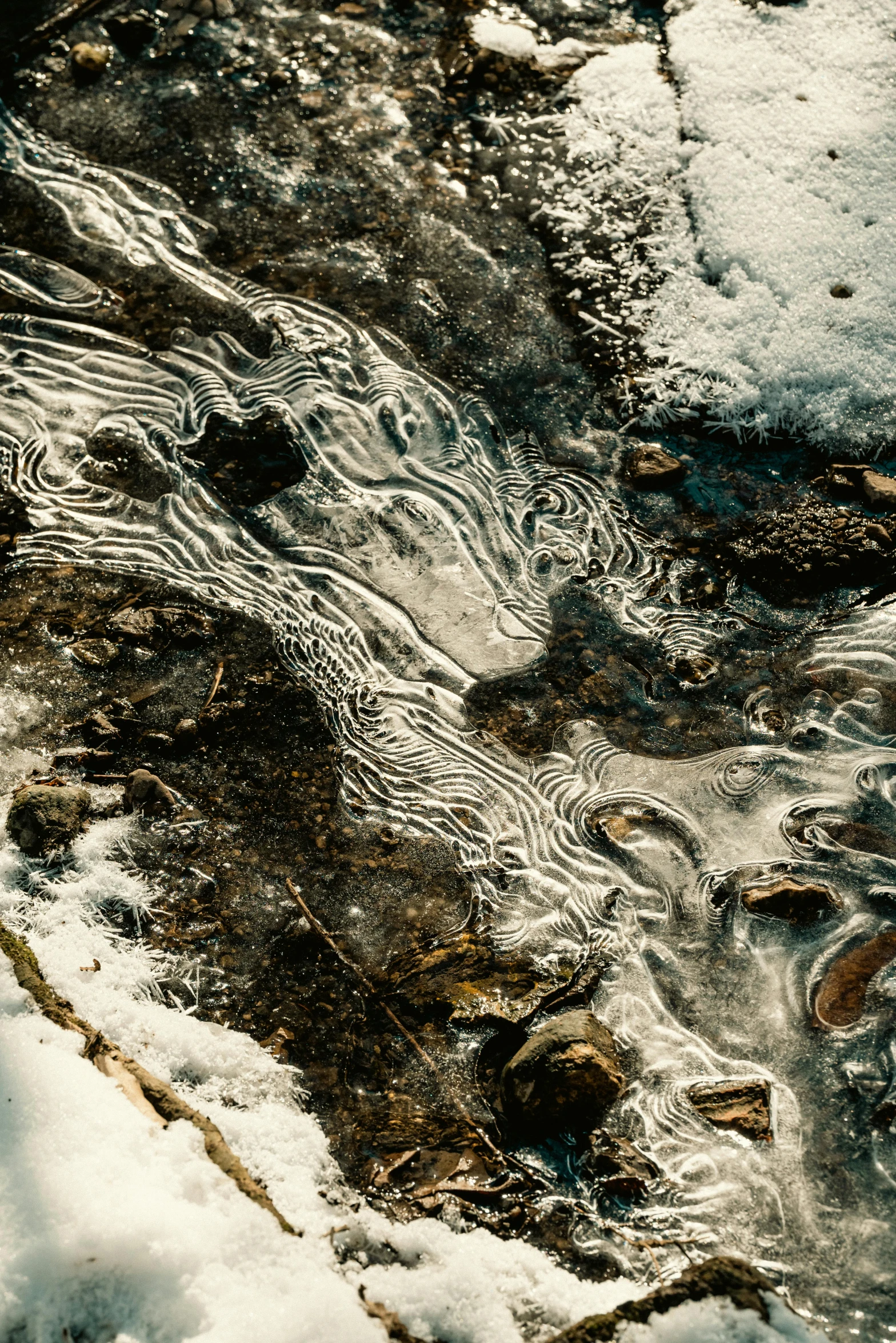 a puddle of water sitting on top of snow covered ground, a microscopic photo, by Neil Blevins, trending on pexels, lyrical abstraction, river rapids, ancient swirls, molten plastic, unsplash photo contest winner