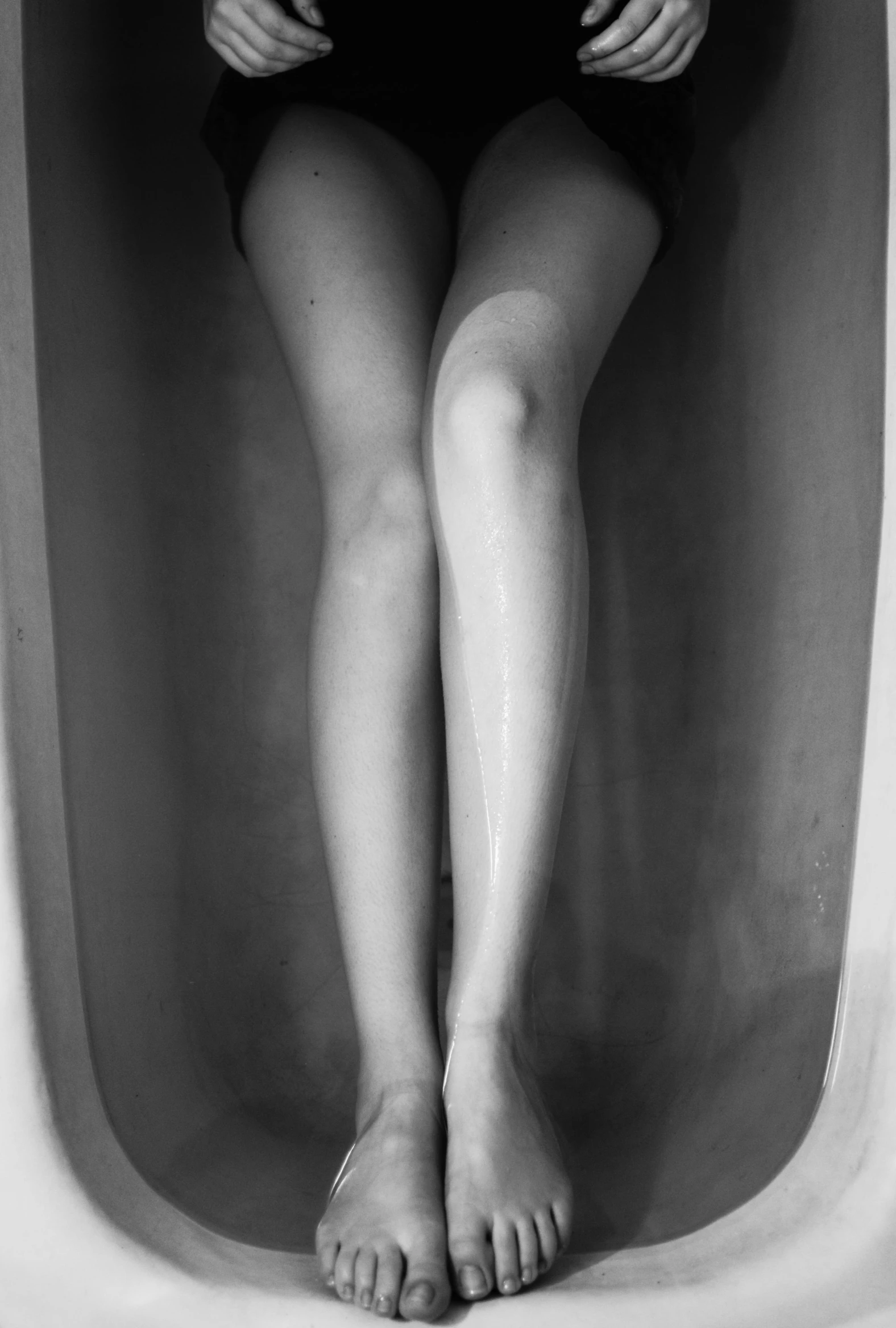 a black and white photo of a woman in a bathtub, inspired by Robert Mapplethorpe, conceptual art, human leg photography, ansel ], uv, 33mm photo