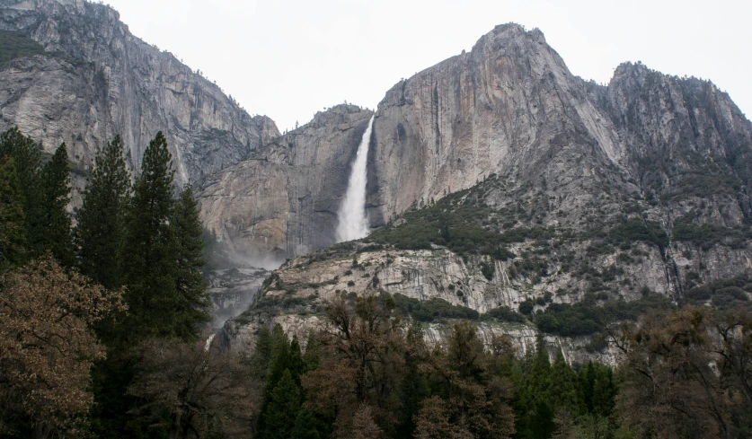 a waterfall coming out of the side of a mountain, by Kristin Nelson, unsplash contest winner, renaissance, yosemite valley, grey, low quality photo, multiple stories