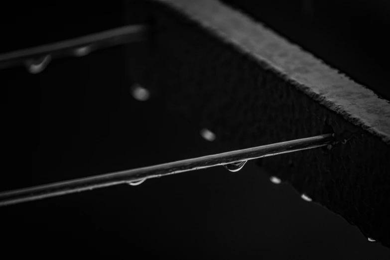 a black and white photo of water droplets, by Daniel Gelon, unsplash, minimalism, metal bars, abstract black leather, iron frame, miniature product photo
