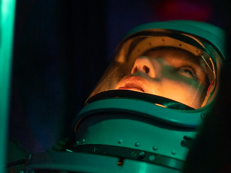 a close up of a person in a space suit, massurrealism, tv show still, head in a jar, glow, promo image