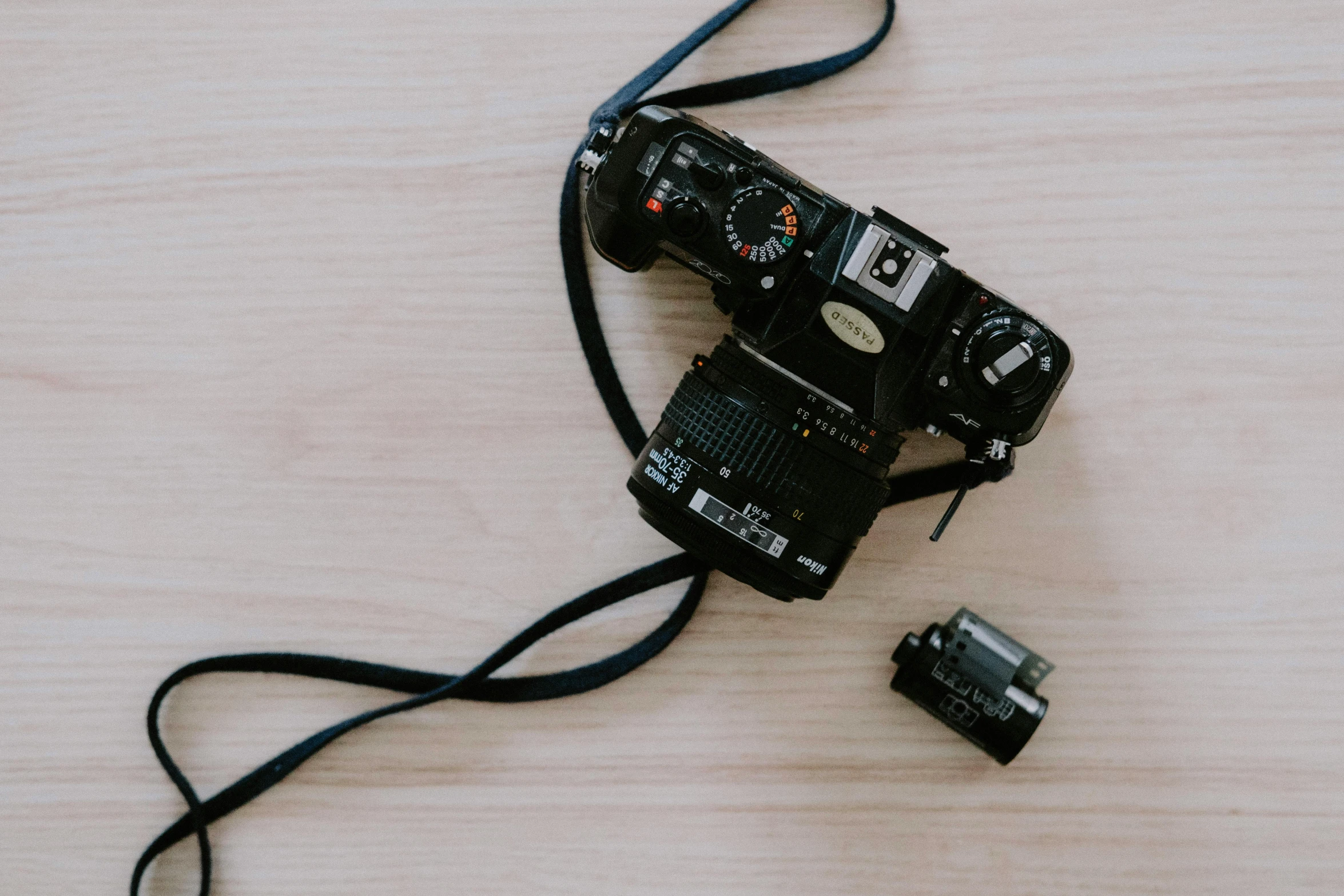 a camera sitting on top of a wooden table, by Carey Morris, unsplash, on a pale background, medium format. soft light, camera on the ground, photograph ”