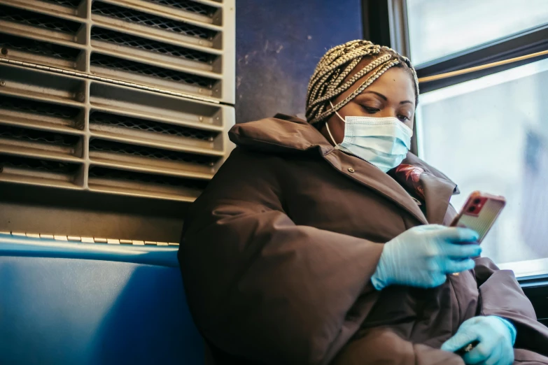 a woman sitting on a bus looking at her phone, by Meredith Dillman, trending on pexels, masked doctors, maria borges, wearing gloves, ny