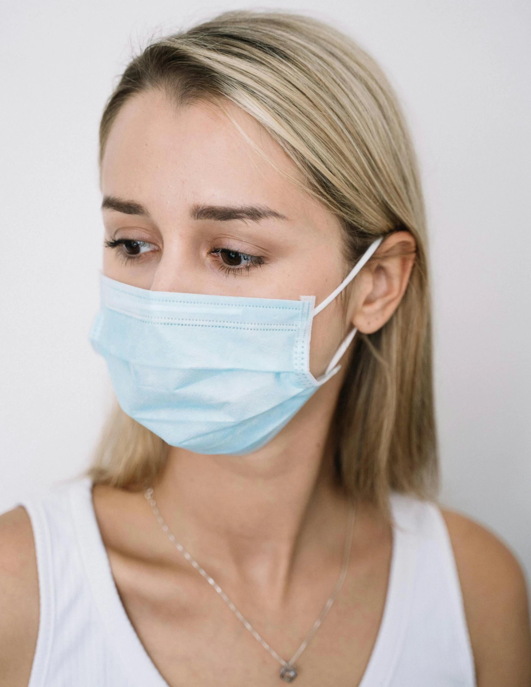 a woman wearing a surgical mask, by Adam Marczyński, trending on pexels, happening, wearing a light blue shirt, product introduction photo, erin moriarty, 😭🤮 💔