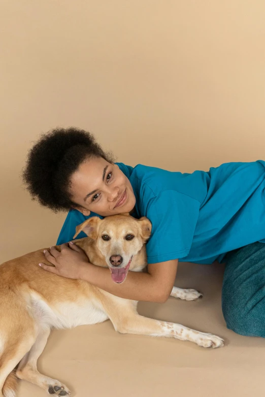 a woman laying on the floor with a dog, healthcare worker, maria borges, plain background, embrace