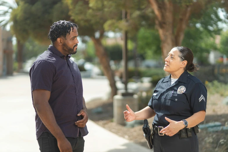 a police officer talking to a woman on a sidewalk, pexels, happening, diverse, california;, two characters, profile image