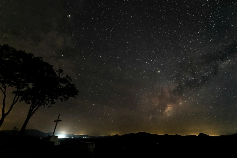 a night sky filled with lots of stars, by Peter Churcher, pexels contest winner, light and space, distant mountains lights photo, visible sky and humid atmosphere, panoramic shot, tree in a galaxy made of stars