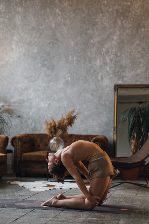 a man doing a yoga pose in a living room, a picture, inspired by Elsa Bleda, pexels contest winner, renaissance, arched back, brown, woman posing, profile image