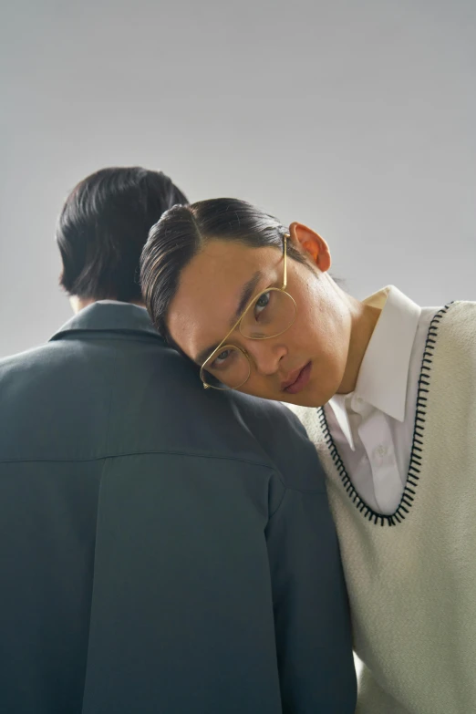 a couple of people standing next to each other, inspired by Fei Danxu, bauhaus, wearing a white sweater, neck zoomed in, non binary model, jewish young man with glasses