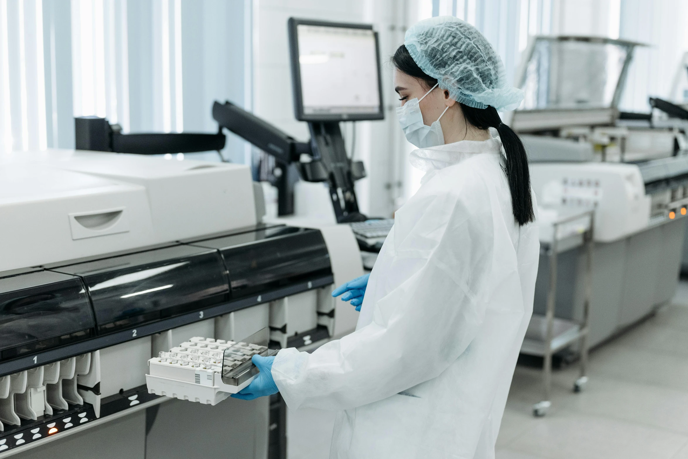 a woman in a lab coat working on a machine, a picture, shutterstock, sterile minimalistic room, low quality photo, thumbnail, profile image