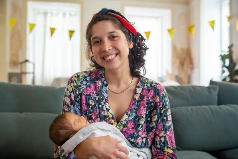 a woman sitting on a couch holding a baby, rebecca sugar, portrait image