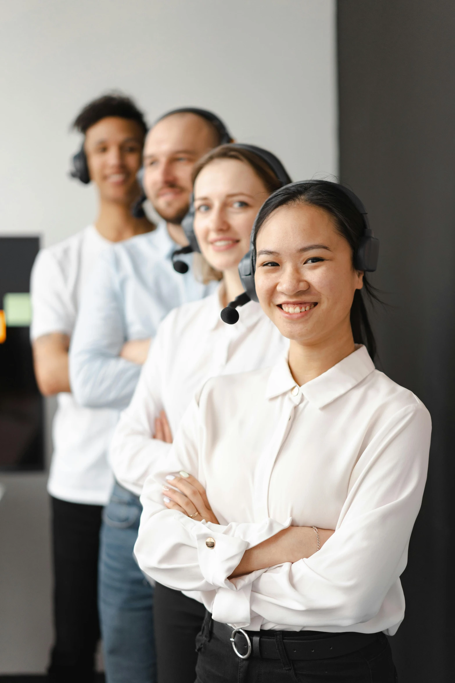 a group of people standing next to each other, wearing a headset, an asian woman, white, professional picture