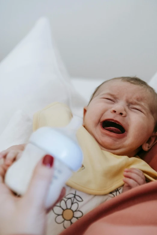 a close up of a person holding a baby, screaming and sad, drinking cough syrup, technological anguish, is totally sad and cries