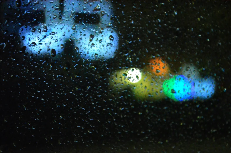 a close up of a window with rain on it, a picture, inspired by Bruce Munro, flickr, graffiti, car lights, colored spotlights, pc screen image