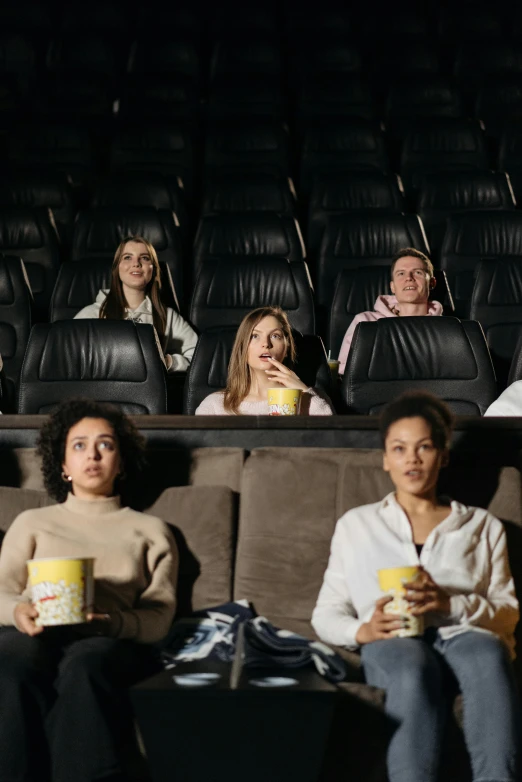 a group of people sitting in a movie theater, square, high-quality photo, ad image, [ theatrical ]