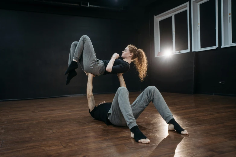 a man and woman doing a handstand in a dance studio, a portrait, inspired by Graham Forsythe, unsplash, square, blank, indoor picture, 2 people