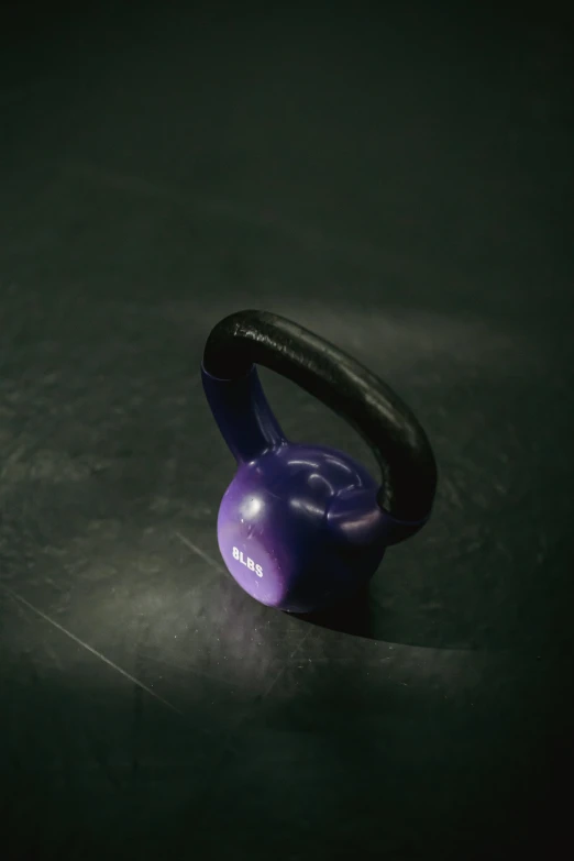 a purple kettle sitting on top of a table, in a gym, ((purple)), strong imagery, close body shot