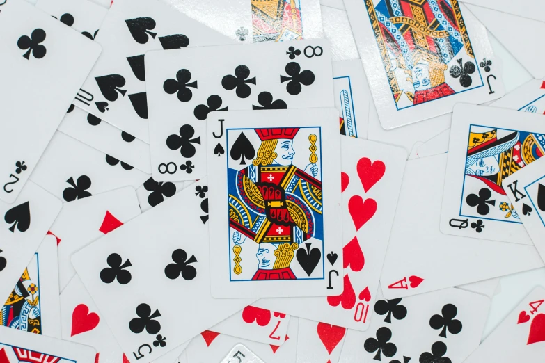 a pile of playing cards sitting on top of a table, a screenshot, pexels, zoomed out to show entire image, game cover, transparencies, multi - coloured