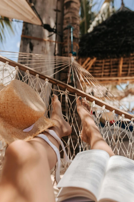 a person laying in a hammock reading a book, pexels contest winner, wearing straw hat, white sarong, netting, charts