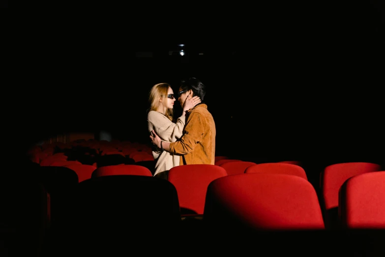 a man and a woman standing next to each other in a theater, a picture, by Julia Pishtar, pexels, romanticism, making out, sitting in a movie theater, hedi slimane, youtube thumbnail