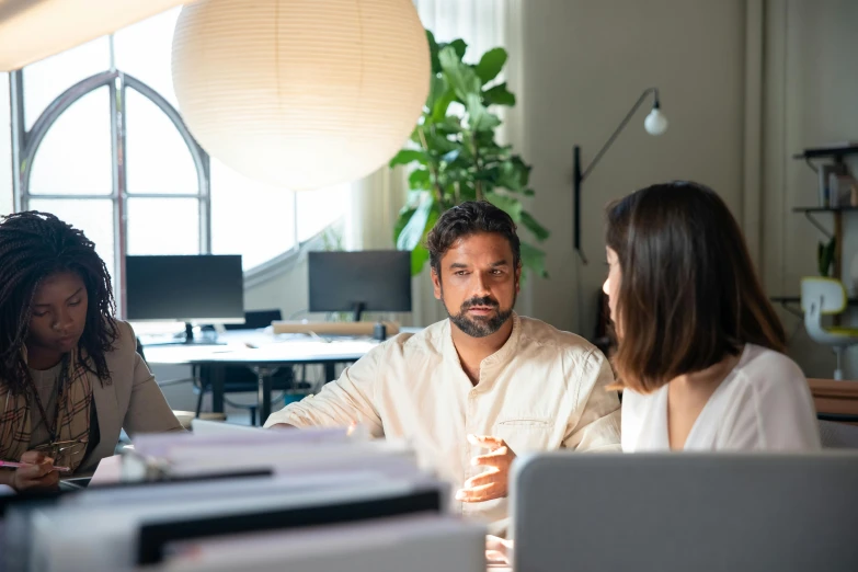 a group of people sitting around a table with laptops, pexels contest winner, renaissance, two people, sitting in office, 9 9 designs, looking across the shoulder