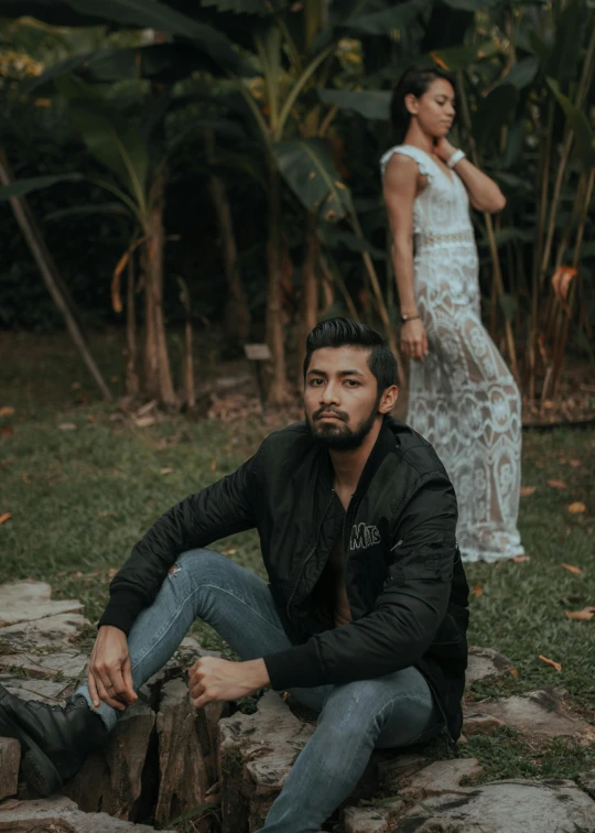 a man sitting on a rock next to a woman, an album cover, by Byron Galvez, pexels contest winner, sumatraism, handsome man, lush surroundings, background image, in front of white back drop