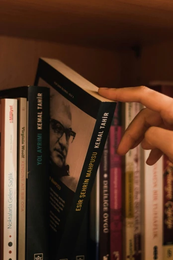 a person reaching for a book on a shelf, inspired by Sunil Das, naturalism, medium close up shot, khomeini, arthur clarke, frontal shot
