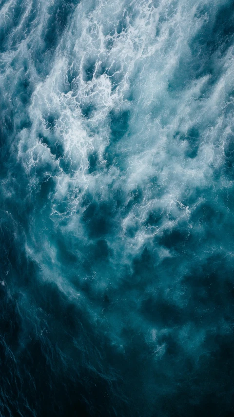 a person on a surfboard riding a wave in the ocean, an album cover, by Jacob Toorenvliet, pexels, undulating nebulous clouds, view from above, dark blue water, concerned