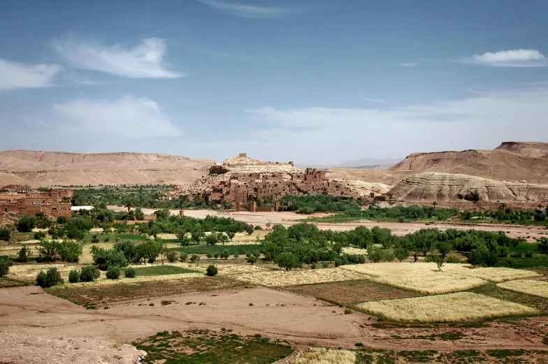 a view of a valley in the middle of a desert, by Peter Churcher, unsplash contest winner, les nabis, red castle in background, historical picture, slide show, moroccan